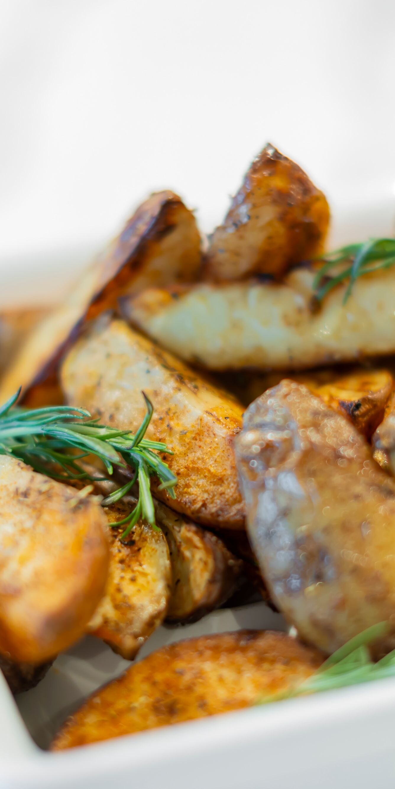 Roasted potato wedges garnished with rosemary