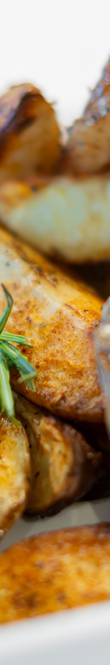 Roasted potato wedges garnished with rosemary