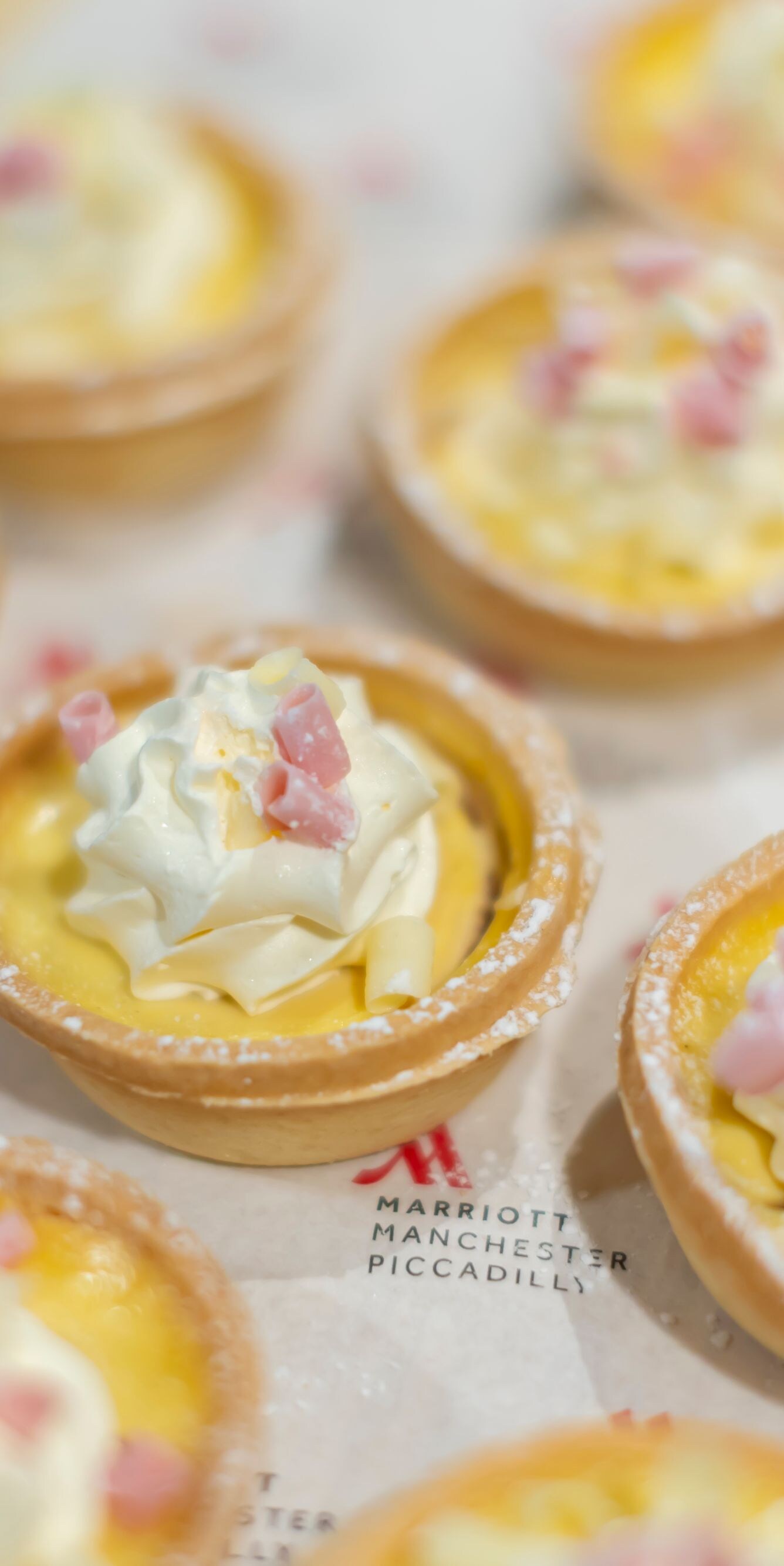 Mini cream-topped tarts on a serving tray