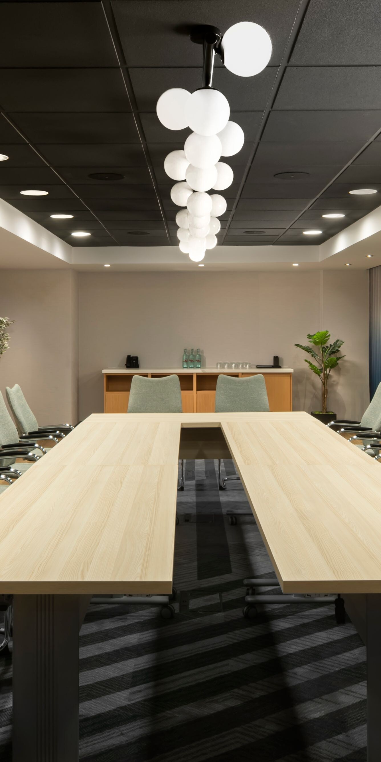 Long boardroom table beside bright windows