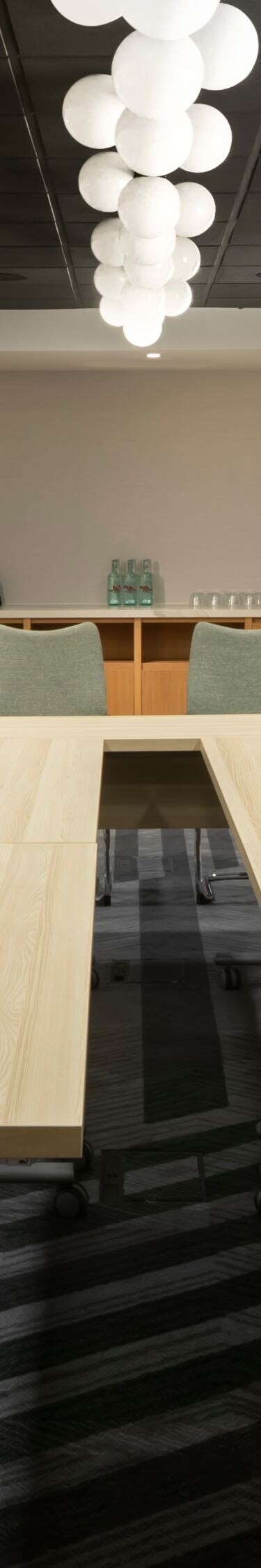 Long boardroom table beside bright windows