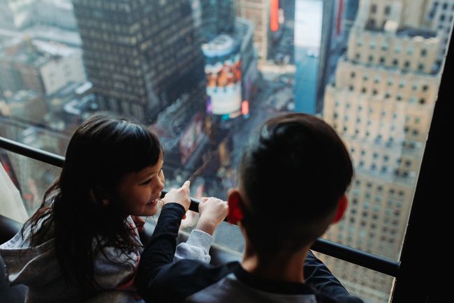 Kids looking out of window at NYC
