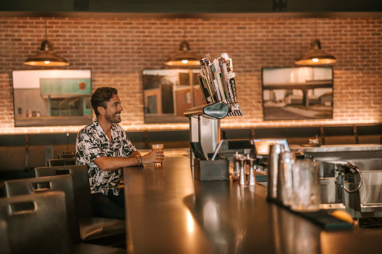 man sitting at bar with beer