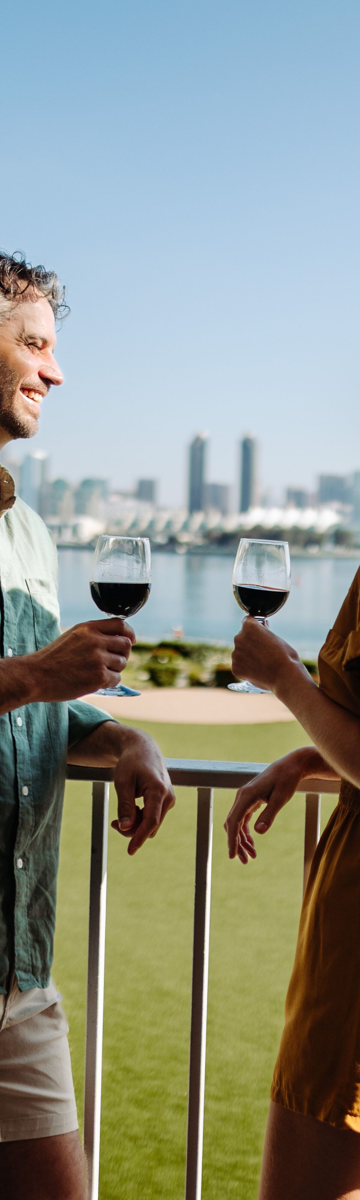 Couple standing on balcony with wine
