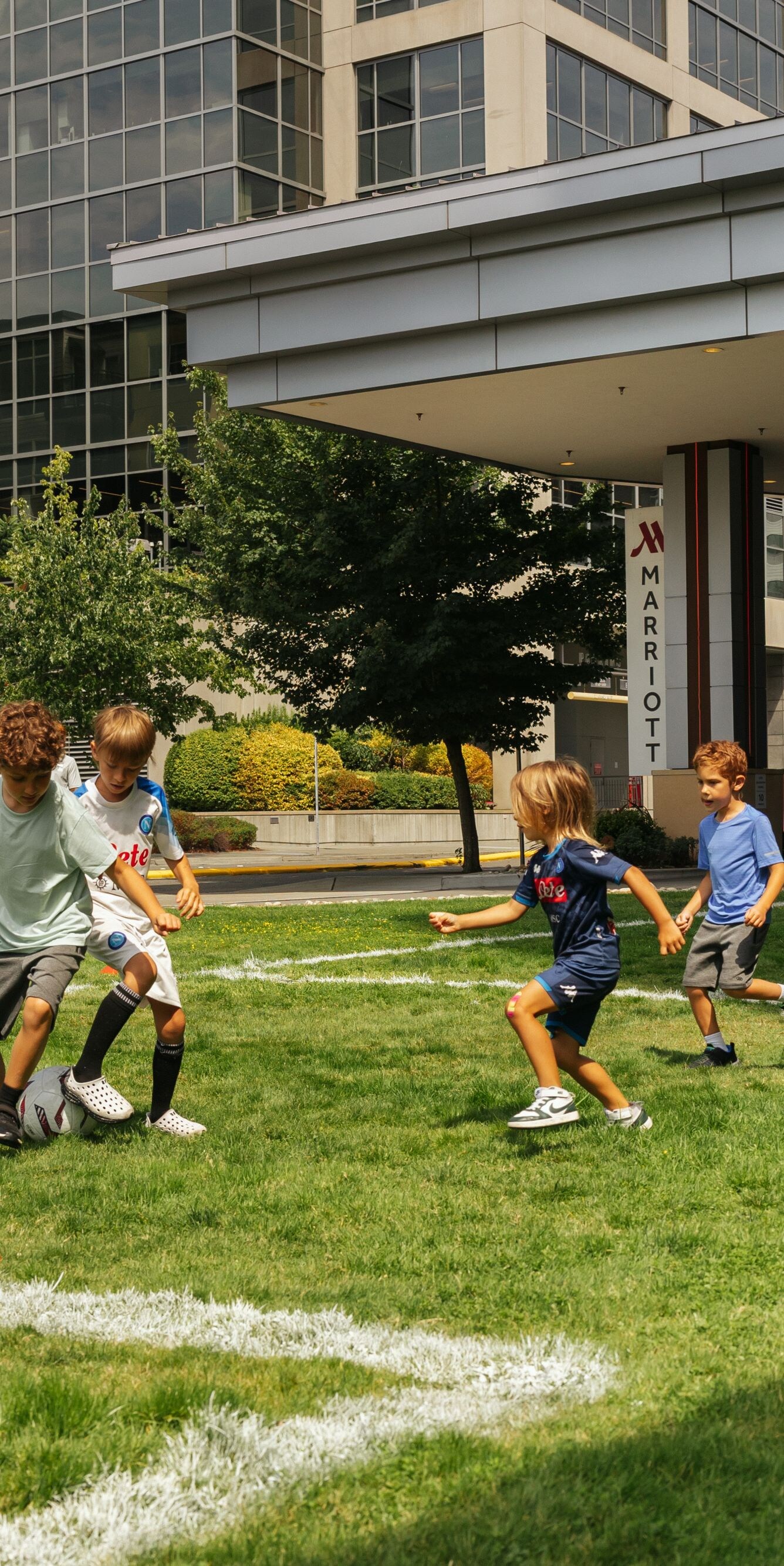 Children playing soccer on outdoor lawn