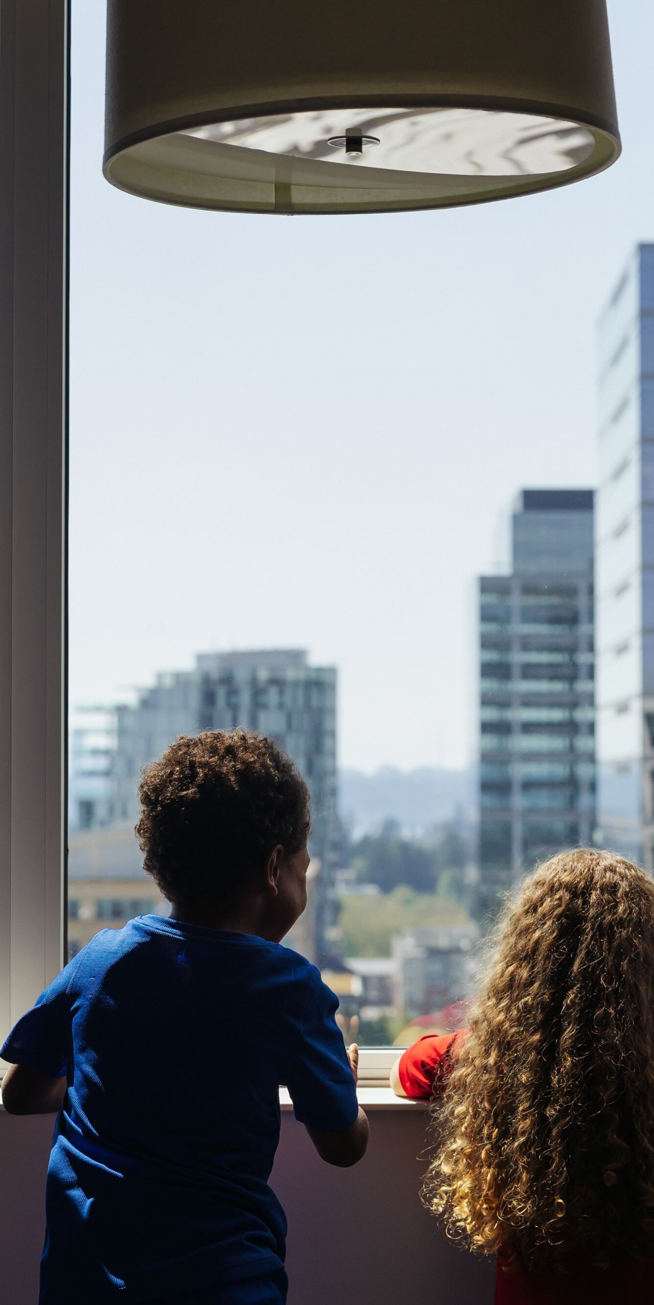 Children looking out a hotel room window
