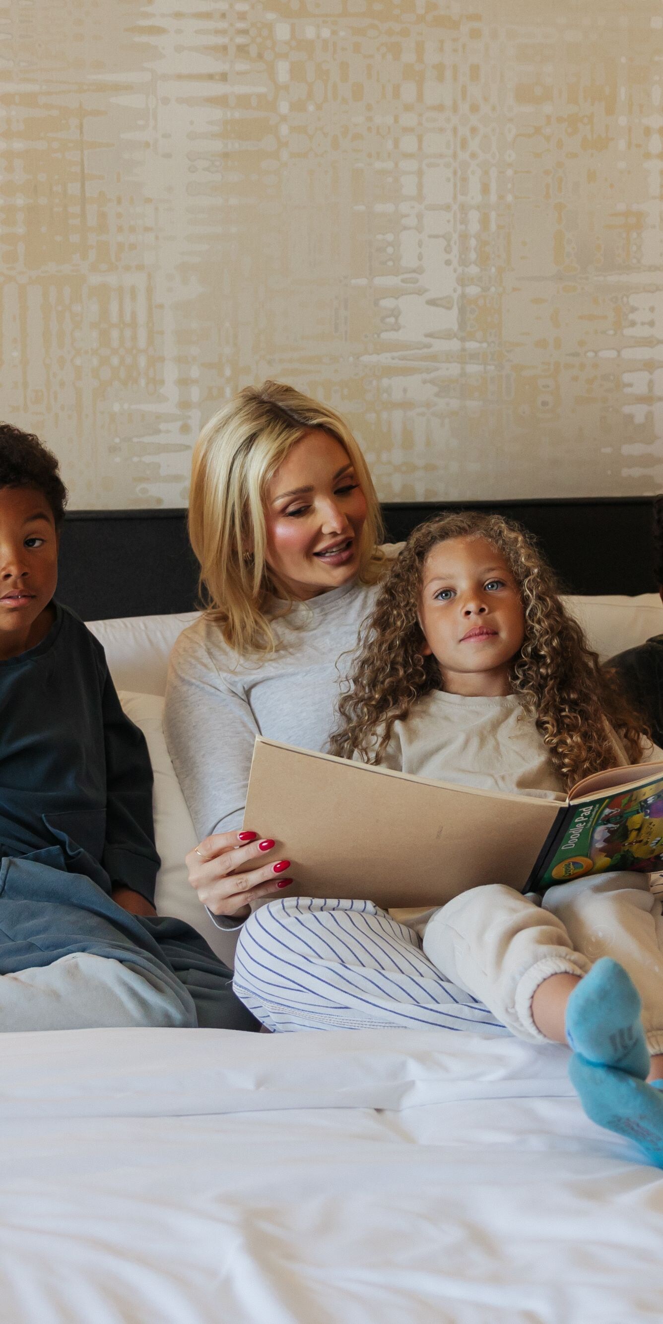 Mother and children in bed reading book
