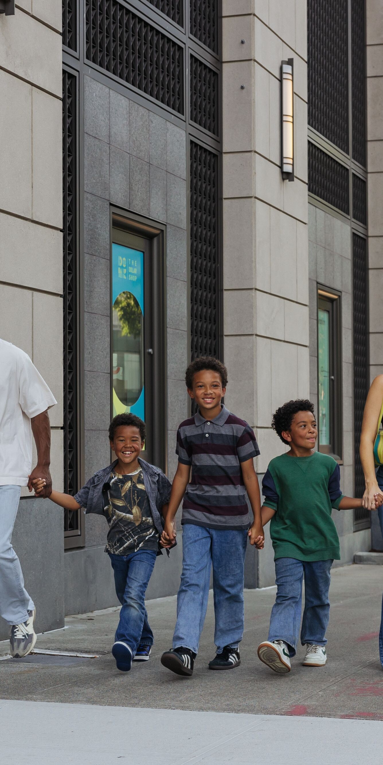 Family walking together on city sidewalk