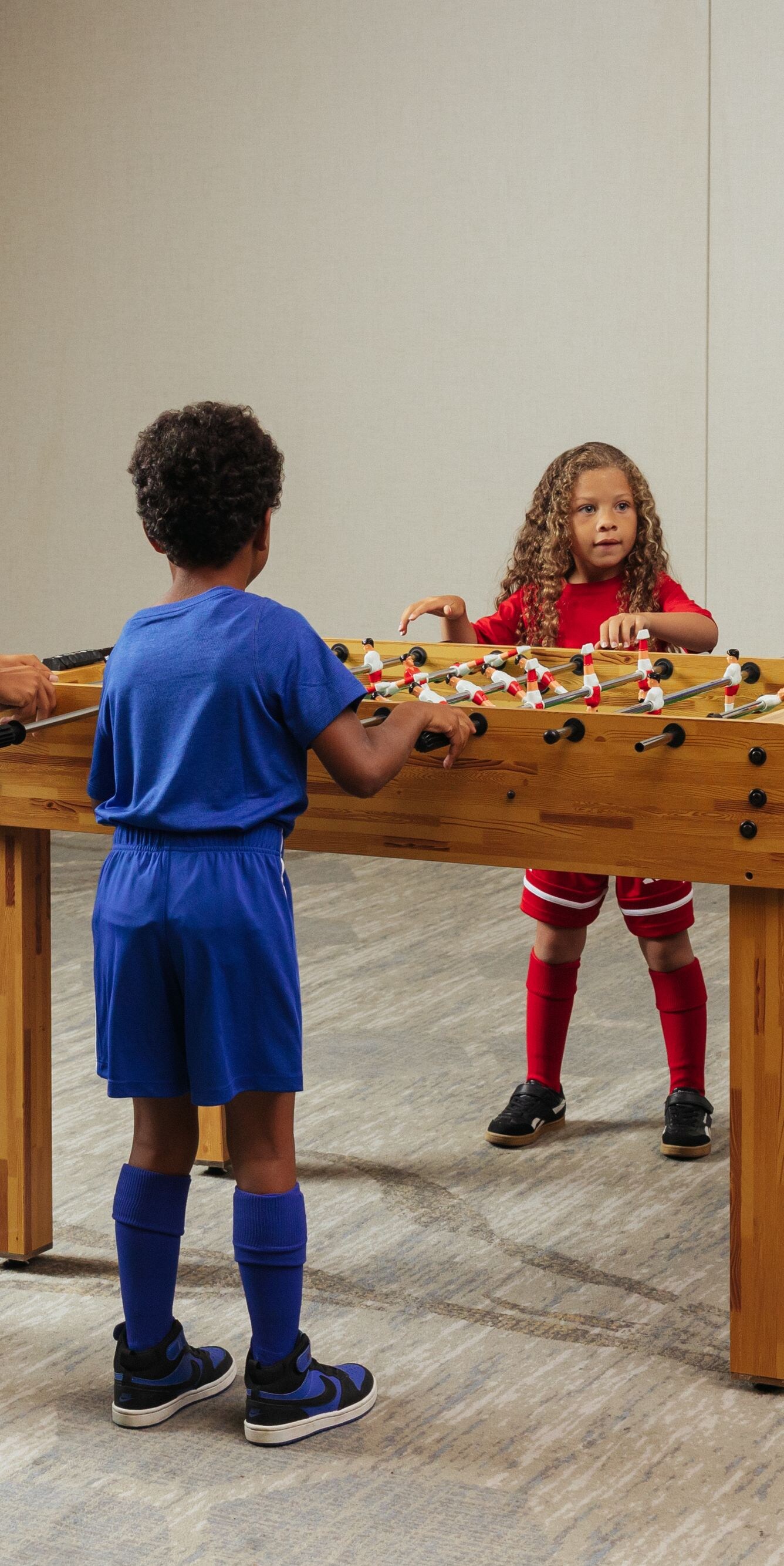 Children playing foosball in a game room