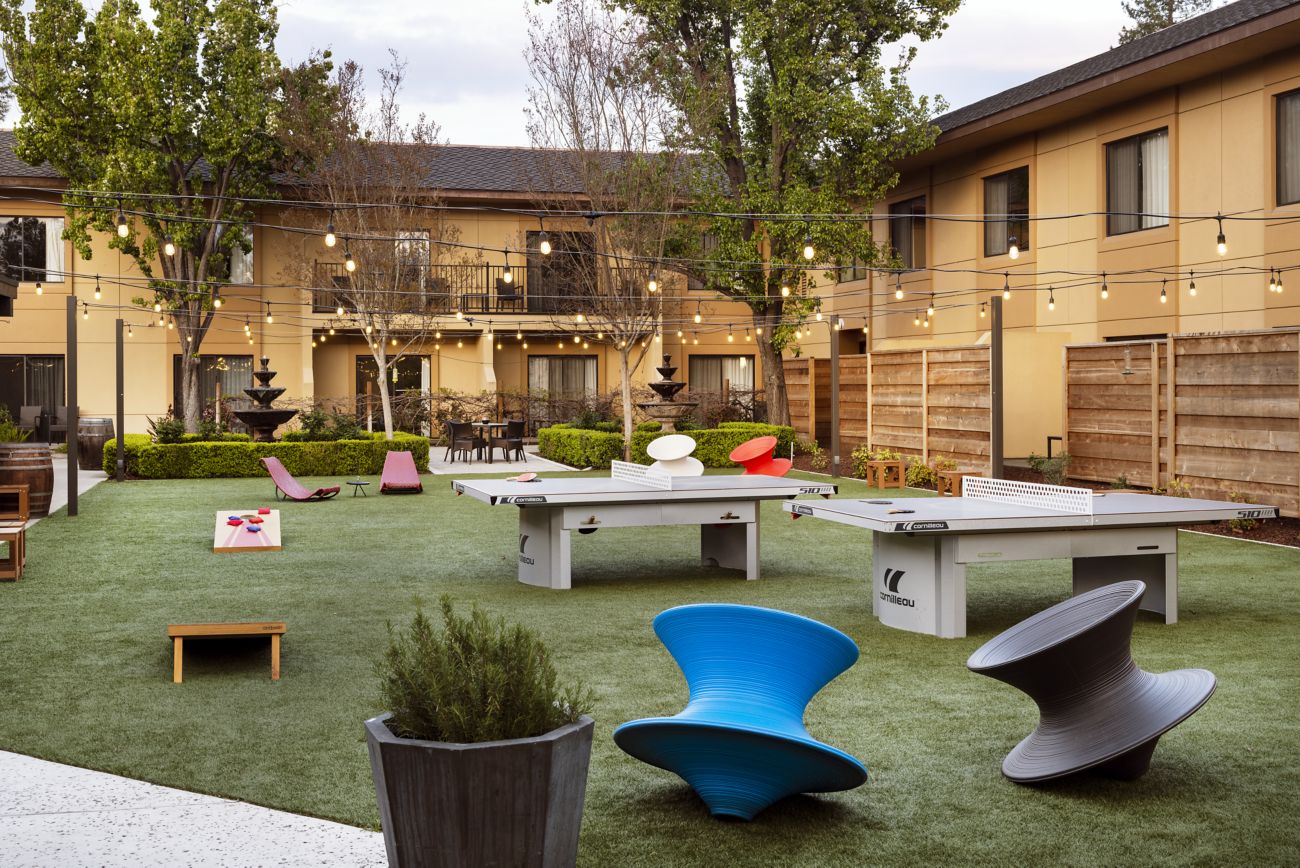 Outdoor lawn with corn hole and ping pong tables