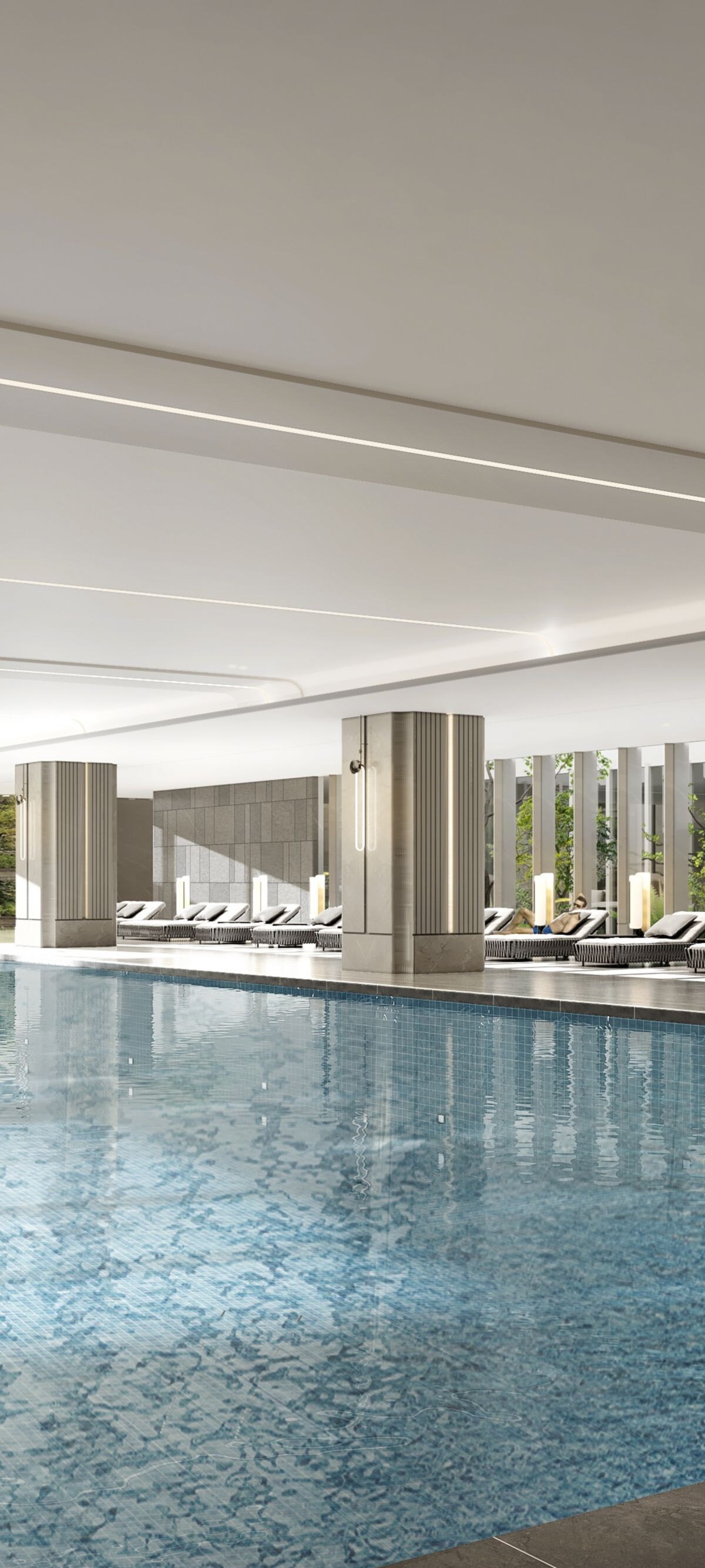 Indoor pool with lounge chairs and greenery