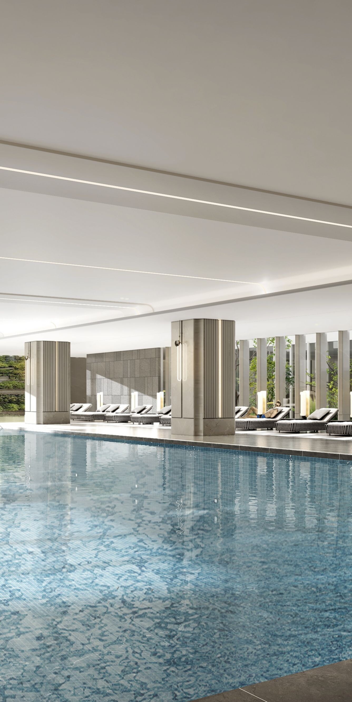 Indoor pool with lounge chairs and greenery