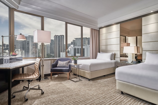 Twin beds with large windows overlooking the city