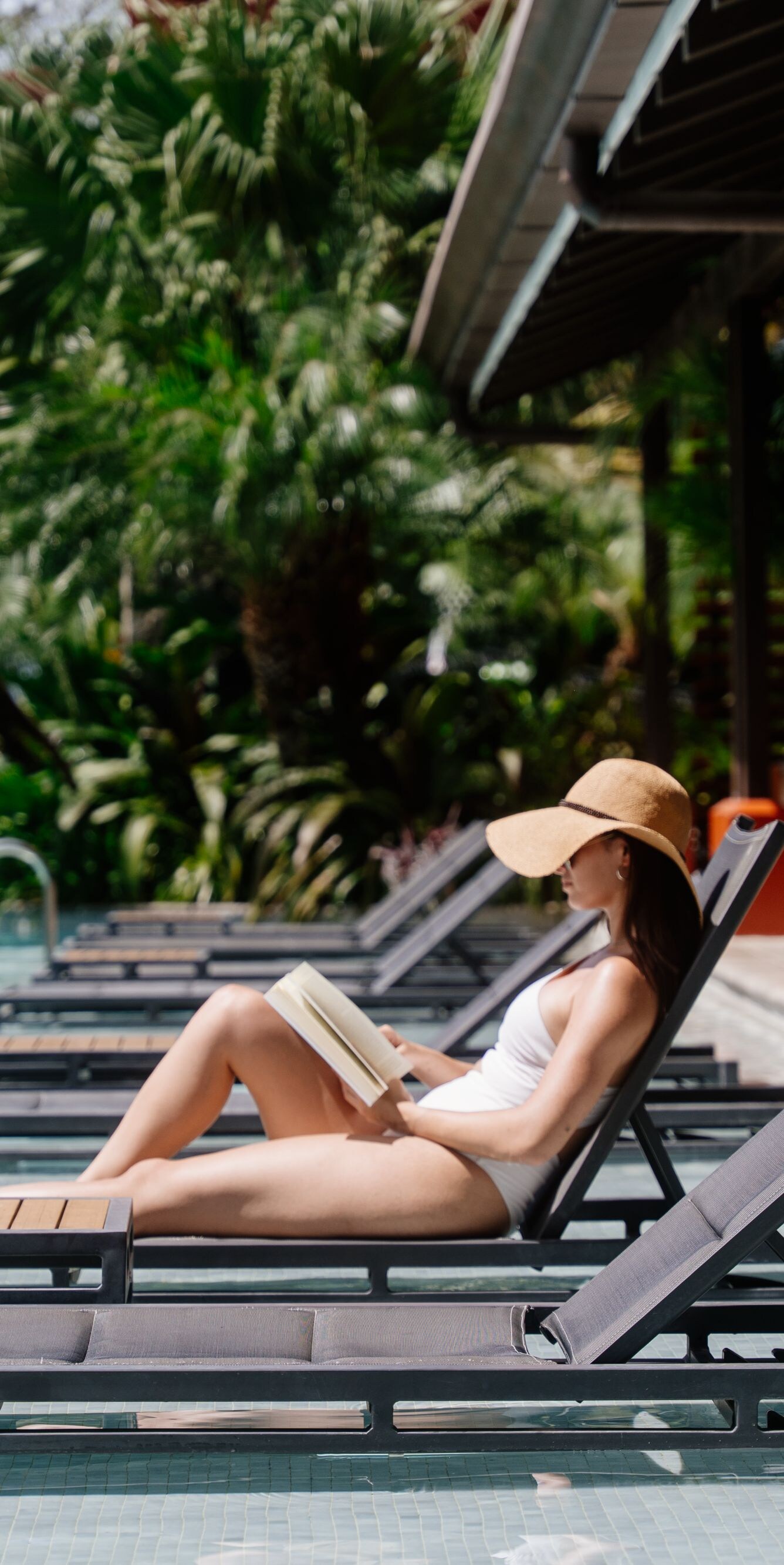 Exterior, piscina, persona con un libro, sillas reclinables