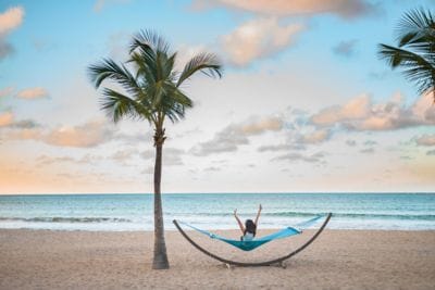 Woman sitting on a hammock on the beach