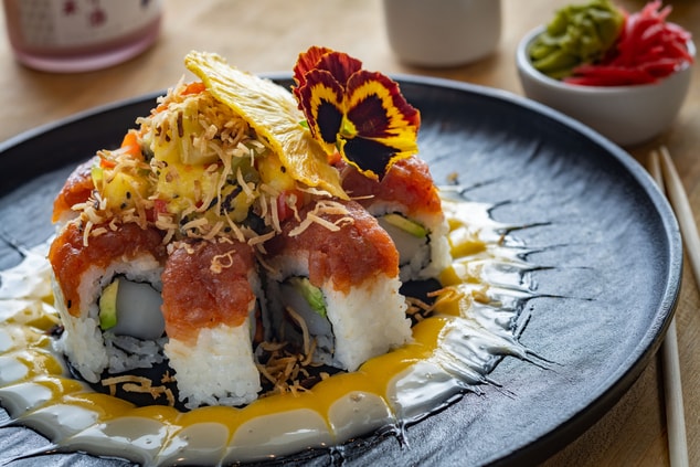 Plate of well-garnished sushi rolls.