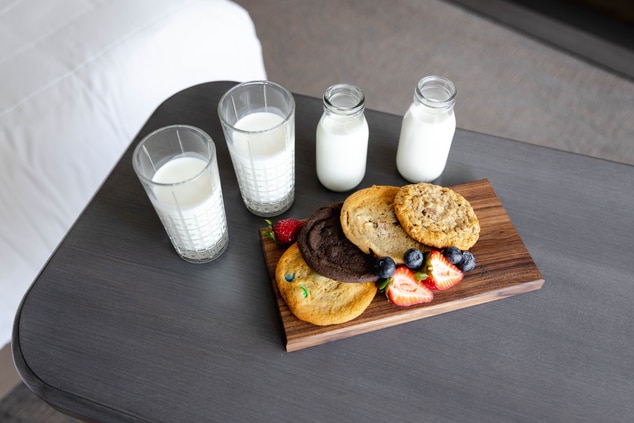 A tray of cookies and four glasses of milk