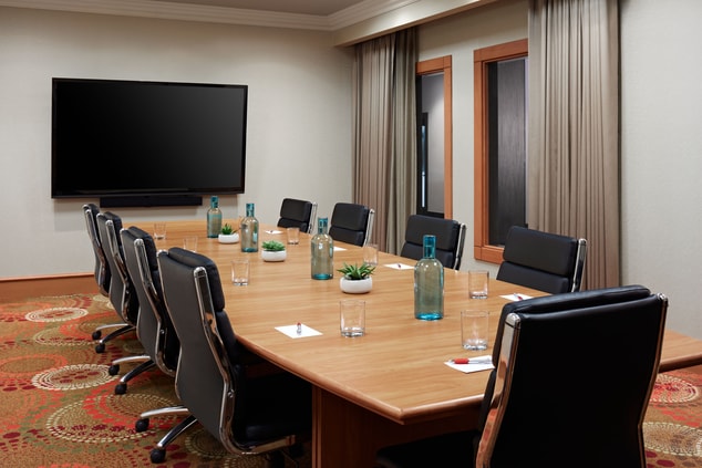 Meeting room with large table, chairs, tv. 