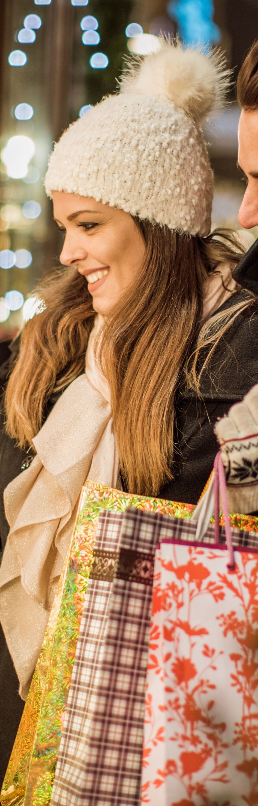 Ein Paar in warmer Kleidung mit Einkaufstüten.