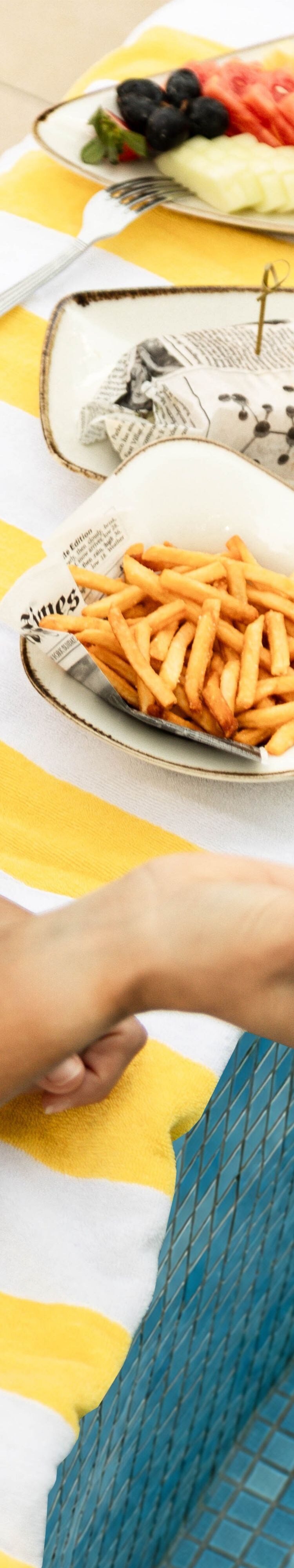 نزيل يستمتع باللفائف والبطاطس المقلية بجانب المسبح