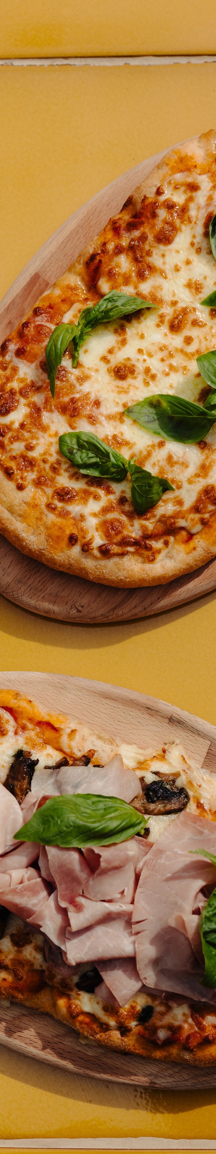 Two Italian pizzas with basil