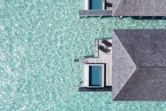 Vista aérea de la villa con atardeder sobre el agua con piscina