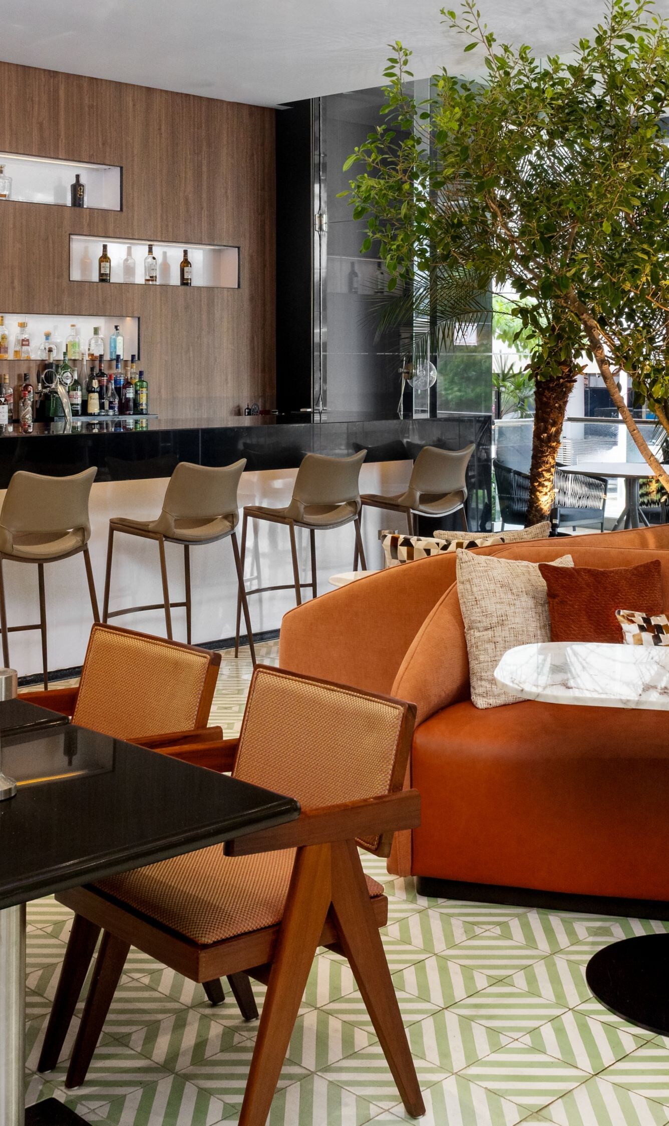 Bar with orange sofa and indoor tree