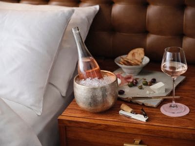 Chilled bottle of Rose near the bed side table