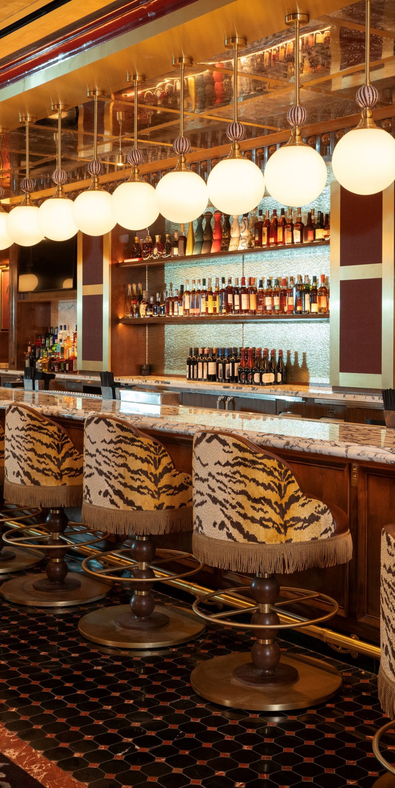 Bar with stools, bottles, round lights above.
