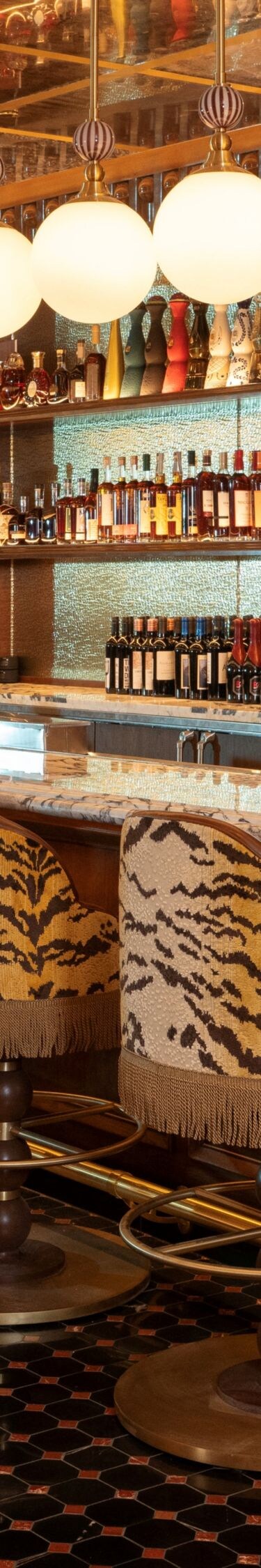 Bar with stools, bottles, round lights above.