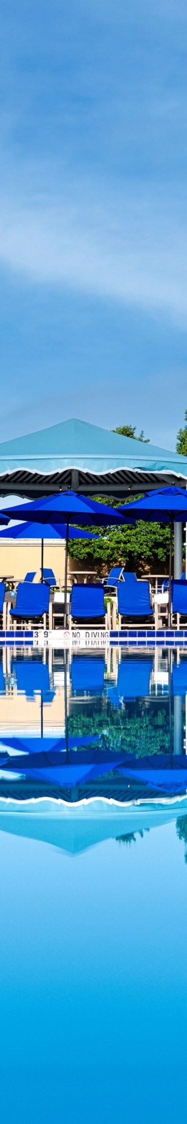 Pool, lounge chairs under covered areas.