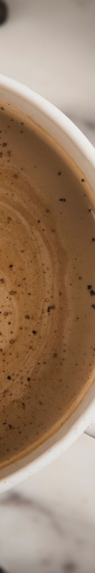 Mug filled with coffee, whipped cream, coffee bean