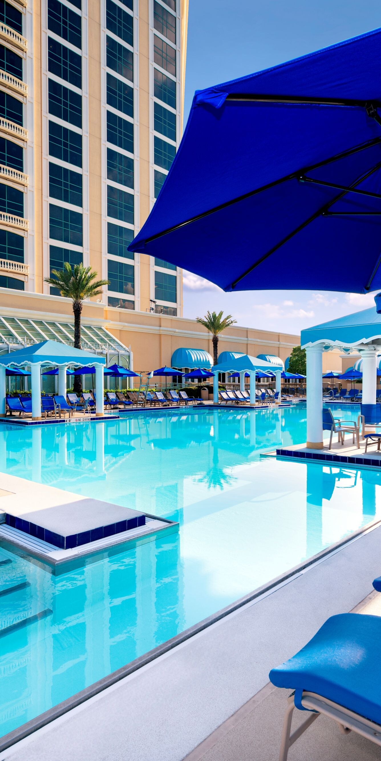 Lounge chairs, umbrellas surround pool area