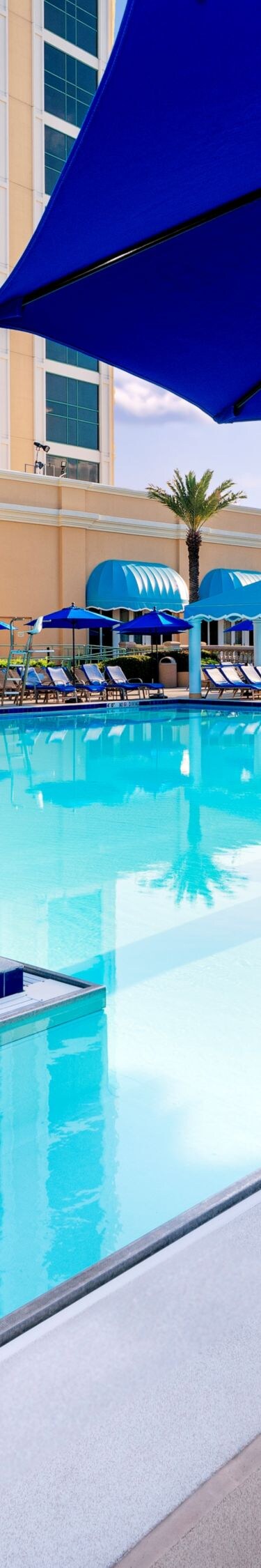 Lounge chairs, umbrellas surround pool area