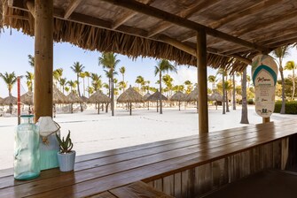 Bar en la playa con palmeras y palapas