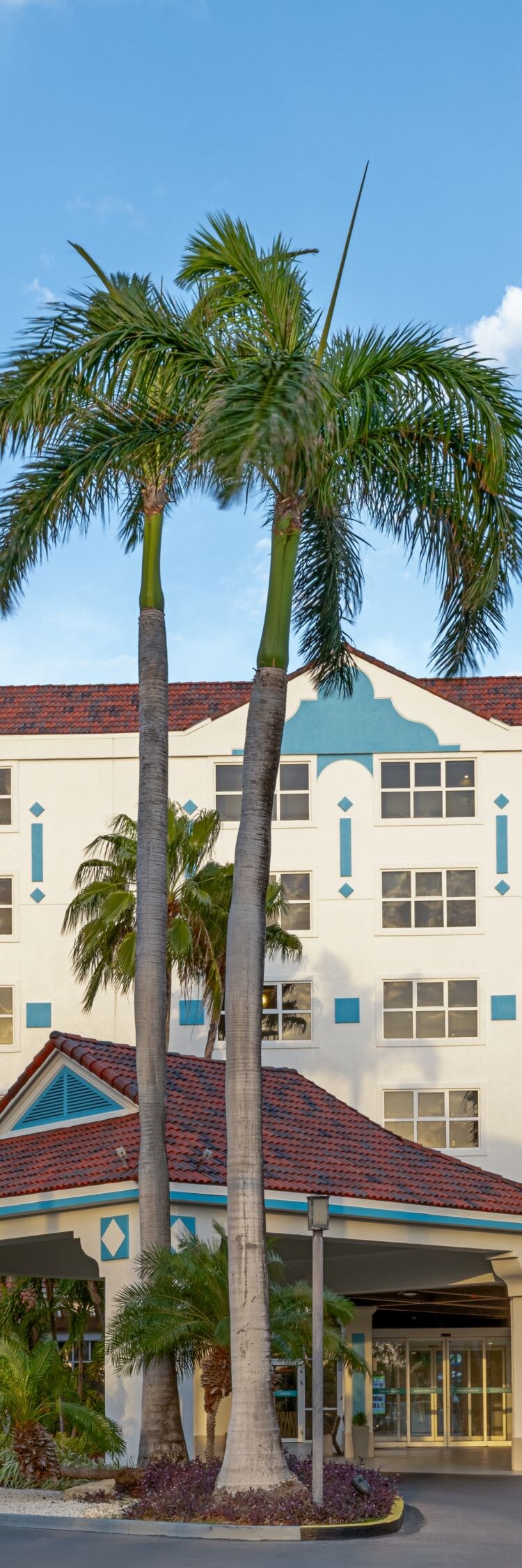 Ingang van het hotel op Aruba met palmbomen