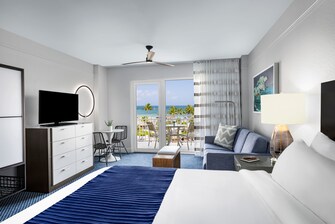 Oceanfront guest room with bed, sofa and balcony