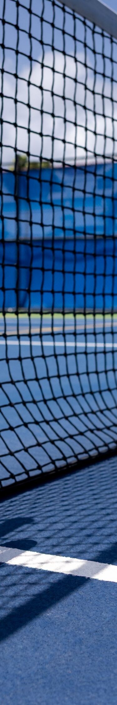 Tennisrackets en -ballen bij het net op een buitenbaan