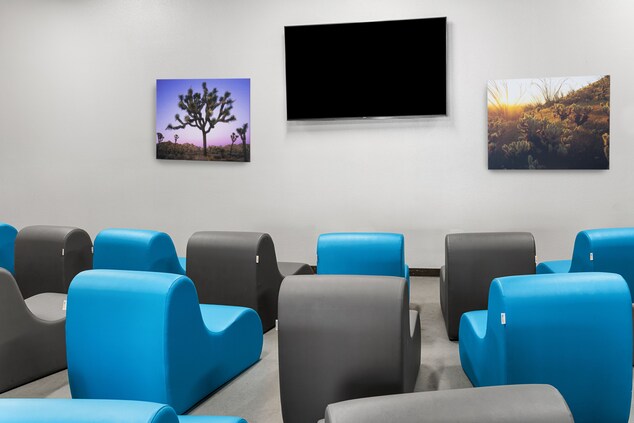Lounge chairs and large screen TV on wall 