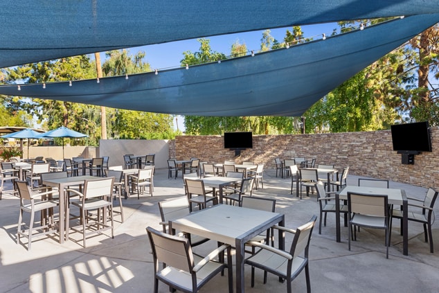 Patio with tables, chairs, TVs on wall