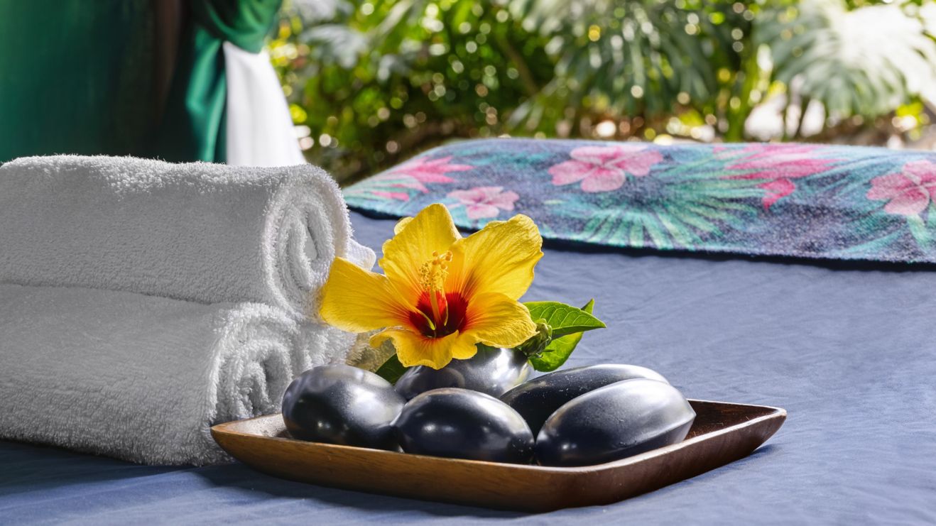 Outdoor massage table with towels, stones, flower