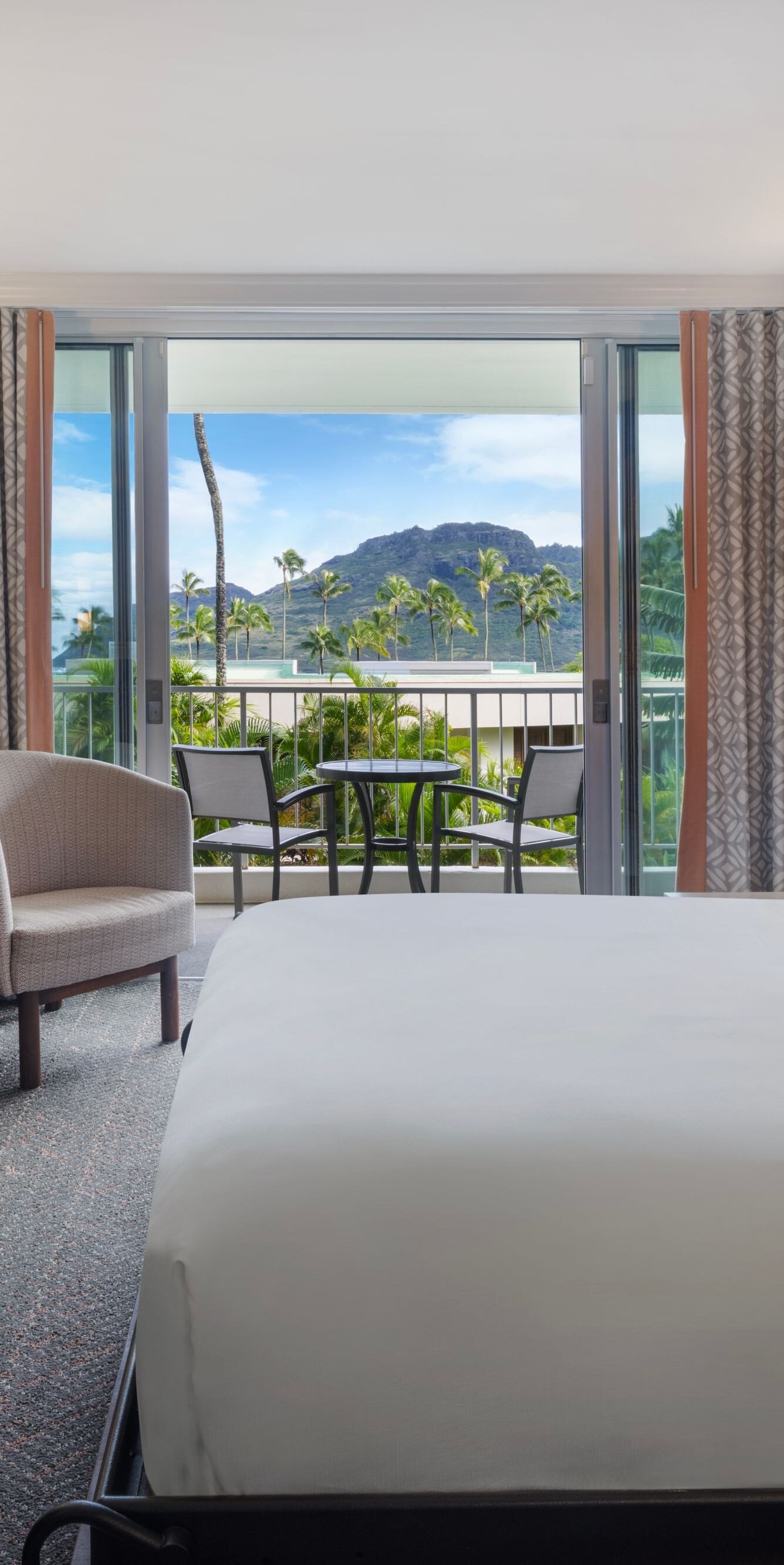 Queen bed with seating area and balcony