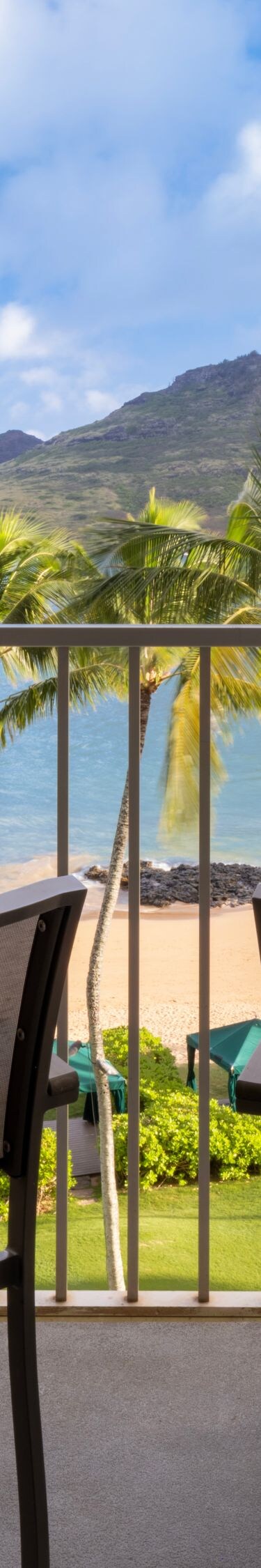 Balcony with tables, chairs and view of beach