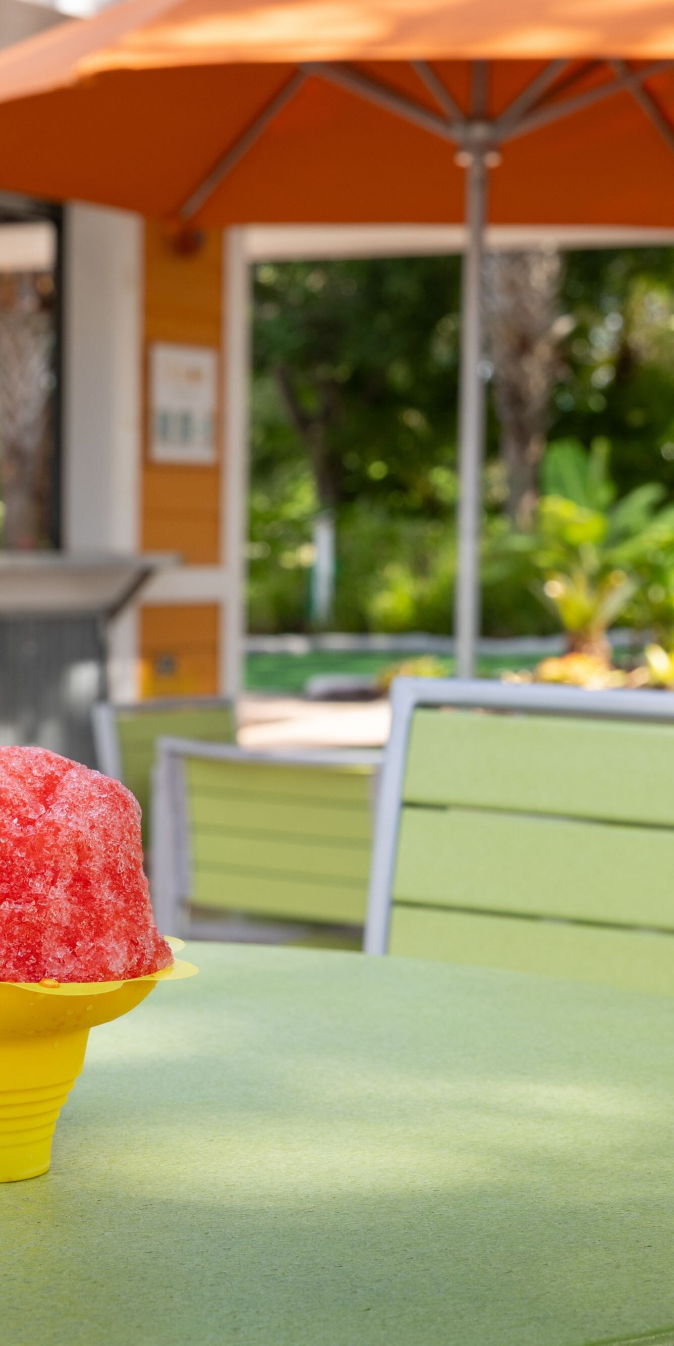 Blaues und rotes Shave Ice auf einem Tisch im Außenbereich