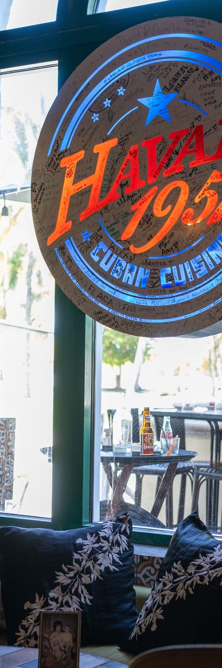 Cartel con el logotipo del restaurante y zona de asientos