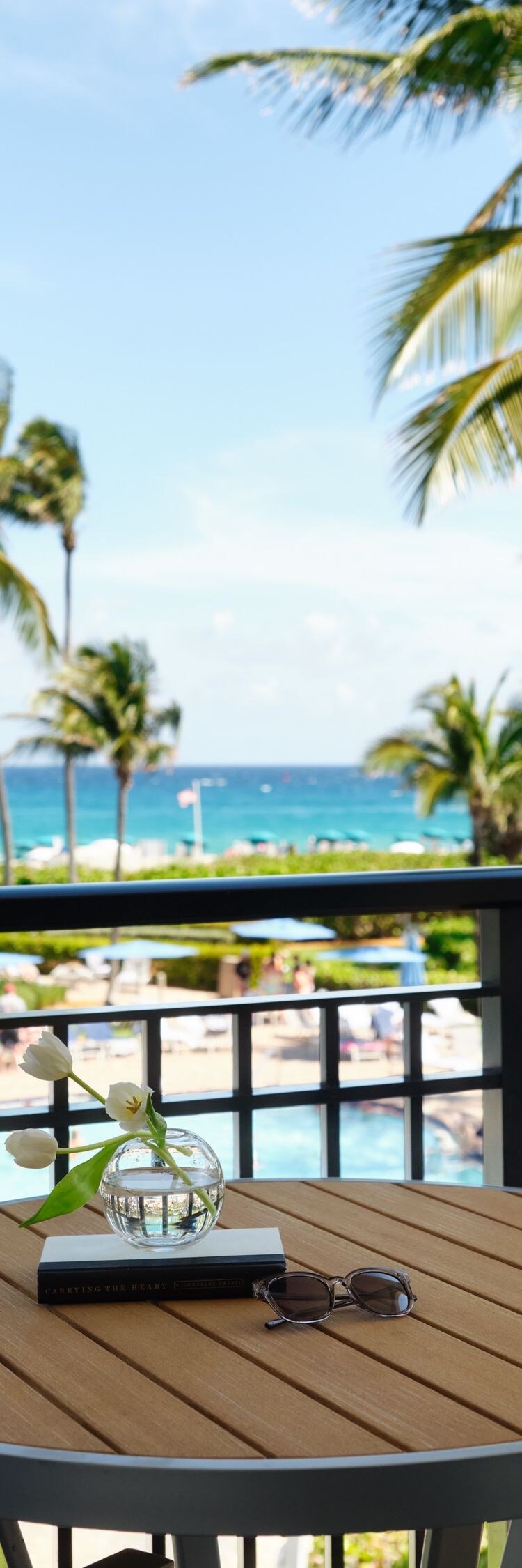 Balcony with table and chairs looking toward ocean
