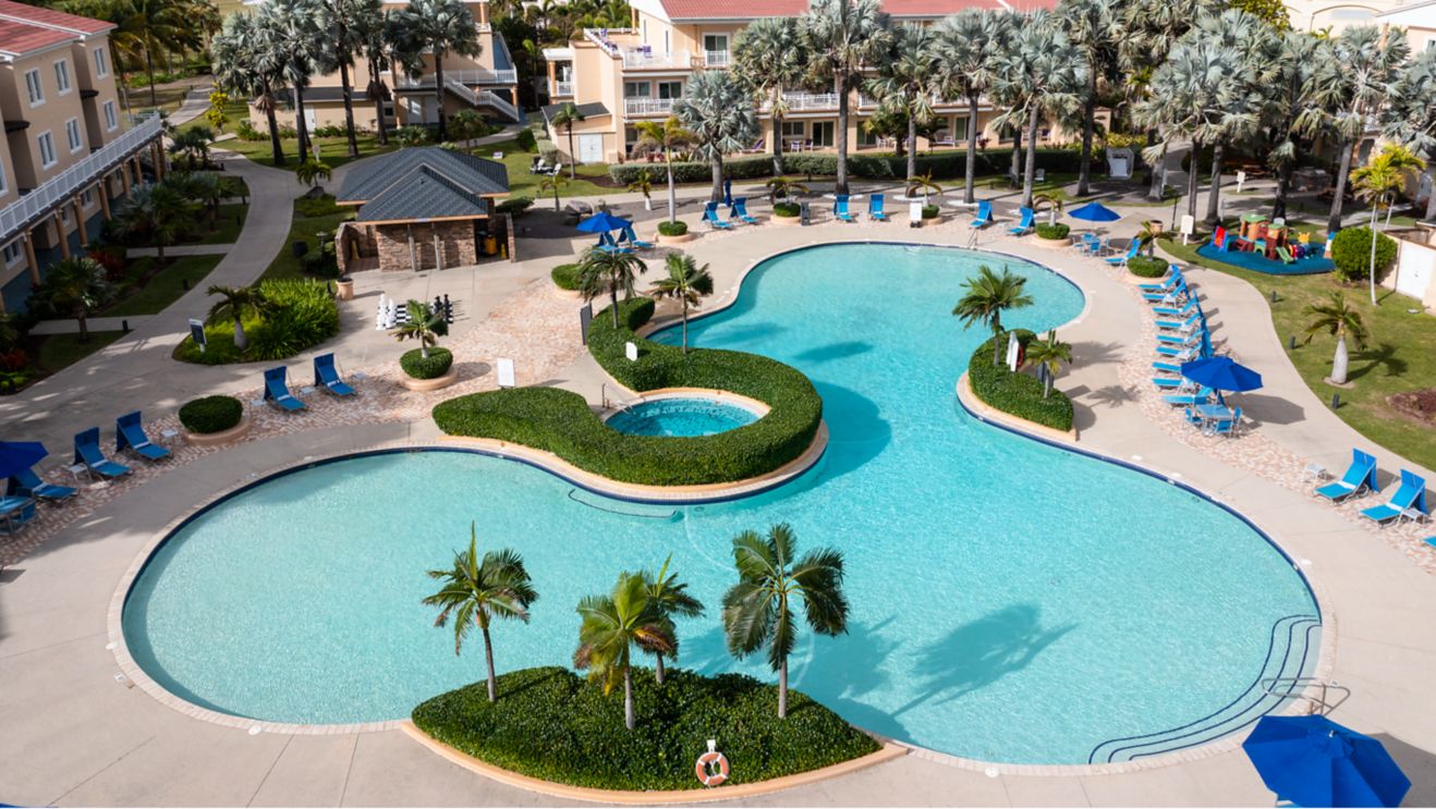 Pool with lounge chairs, resort buildings