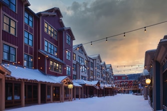 Snow-covered shops with hanging lights