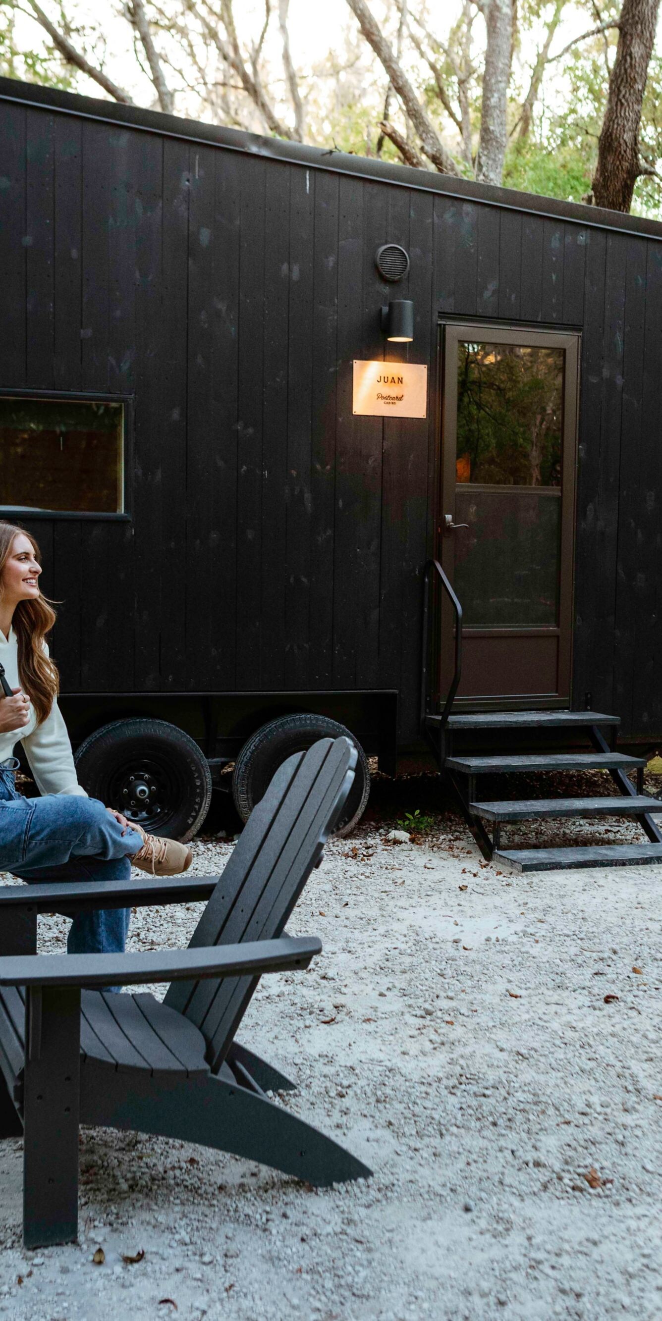 woman sitting on chair outside cabin