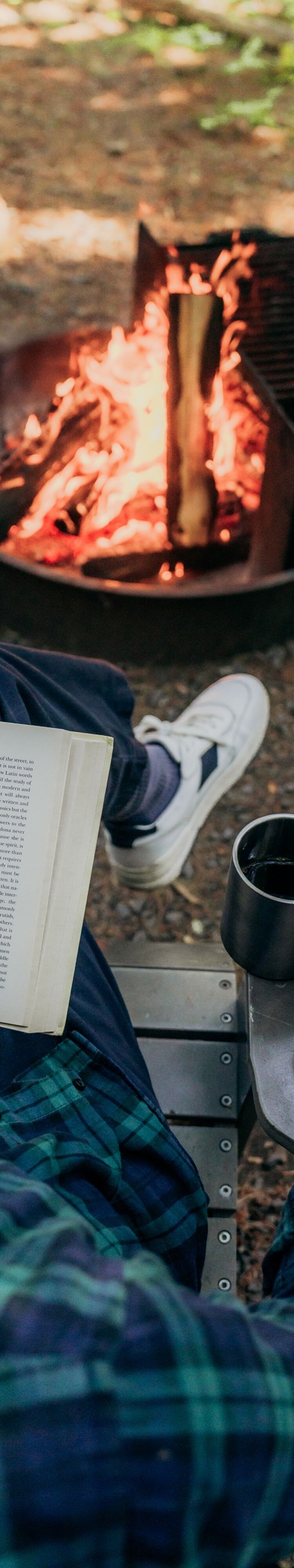 Man sitting reading at fire pit